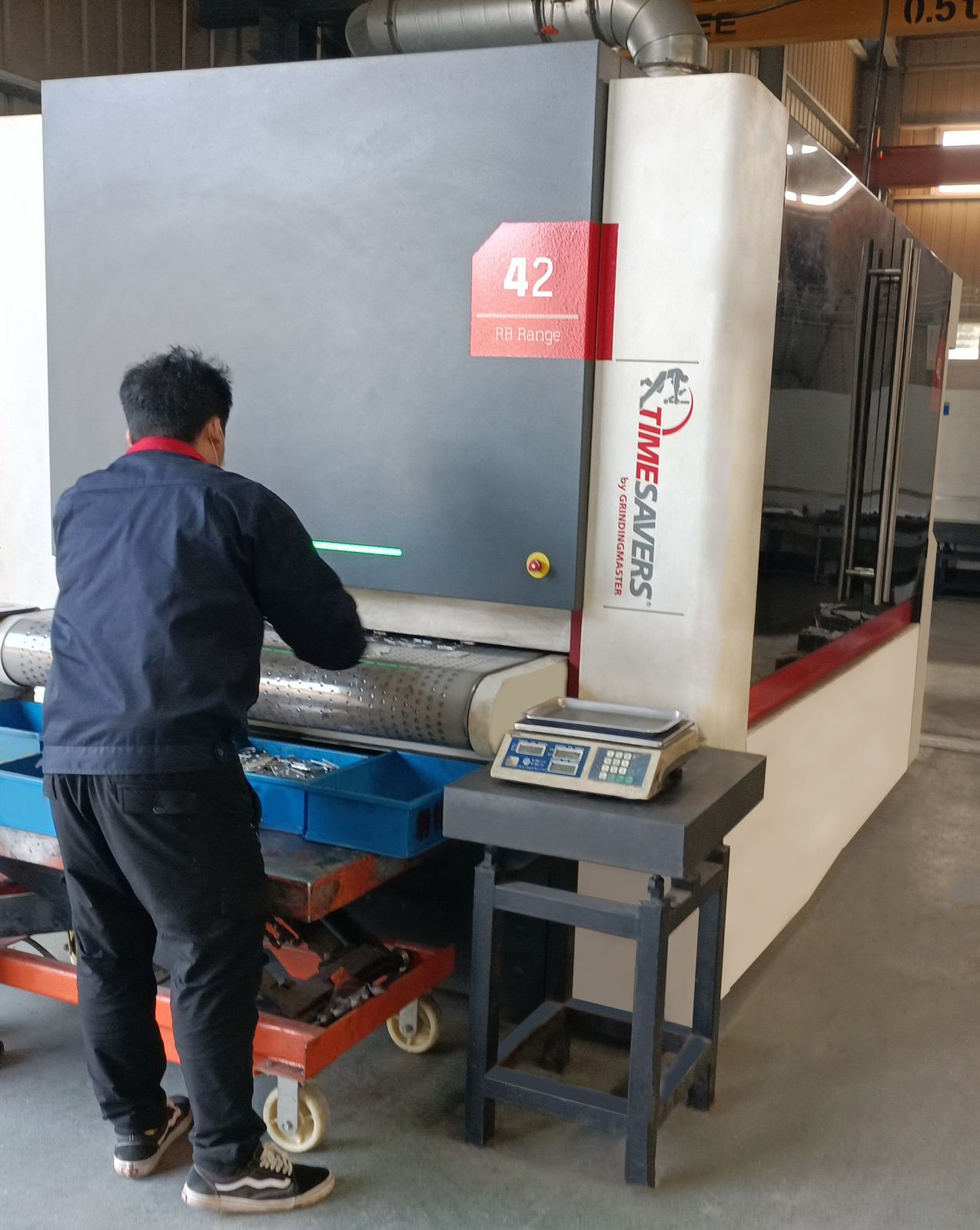 Timesavers wide-belt machine removing burrs from metal sheet