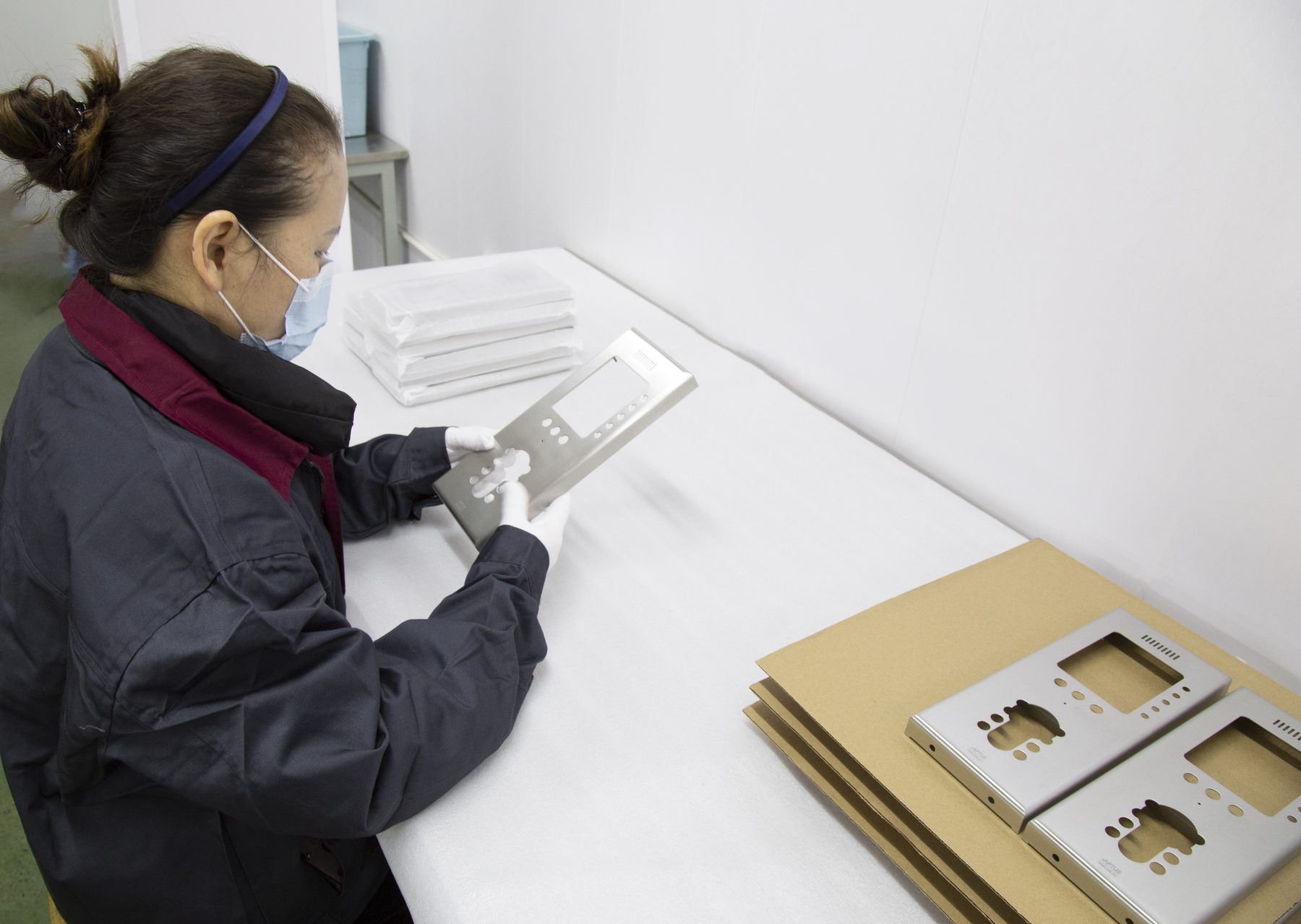 Operator inspecting machined stainless panels